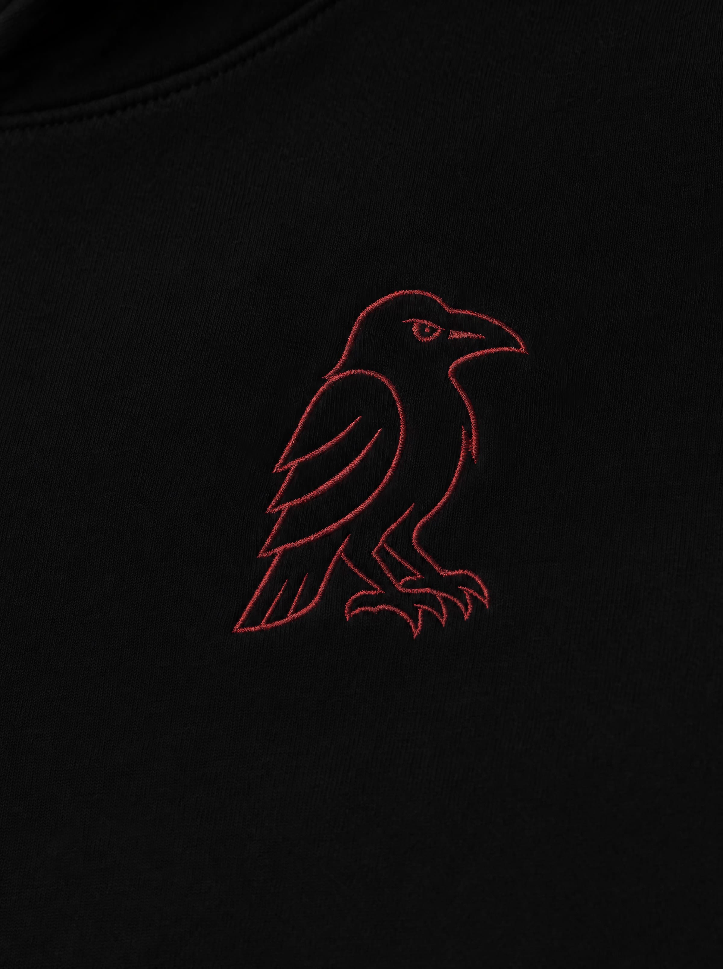 Embroidery close-up — front raven sigil